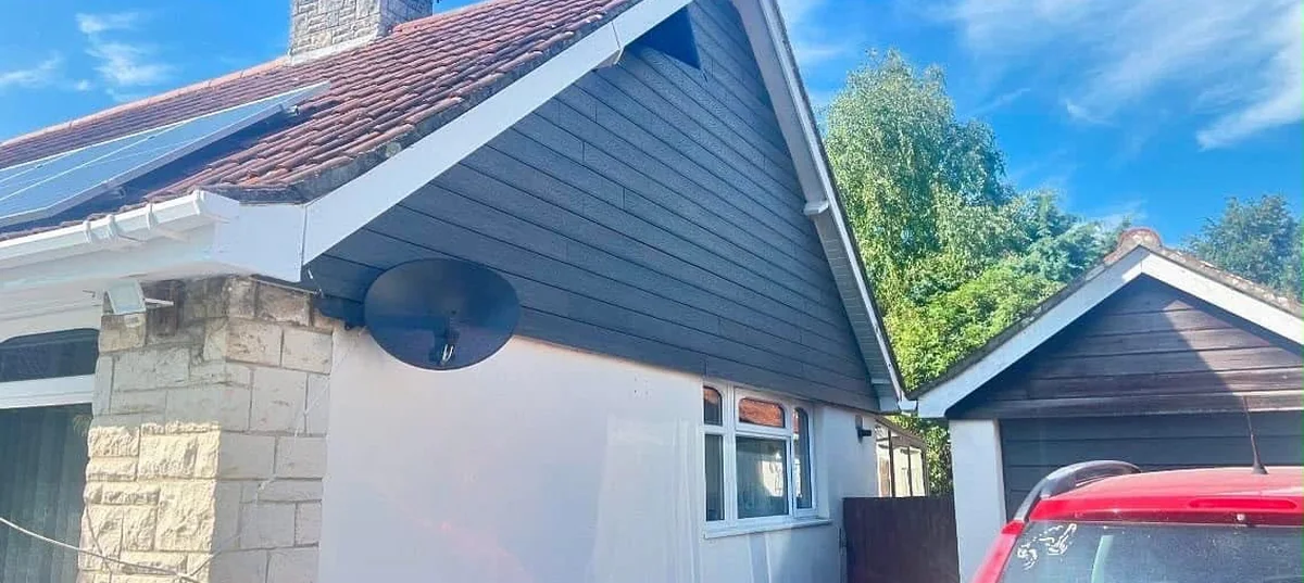 Grey composite cladding on a bungalow gable with new white roofline