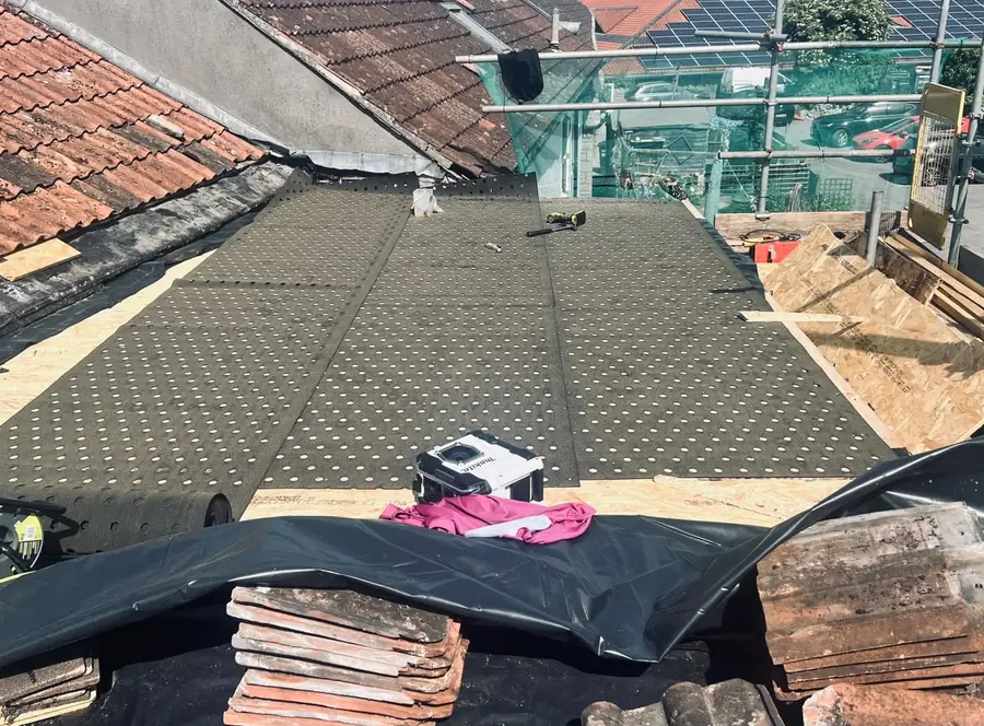 Mineral surfaced felt being laid across a prepared roof deck